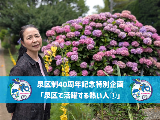 アジサイの前に立ちほほえむ菱さん